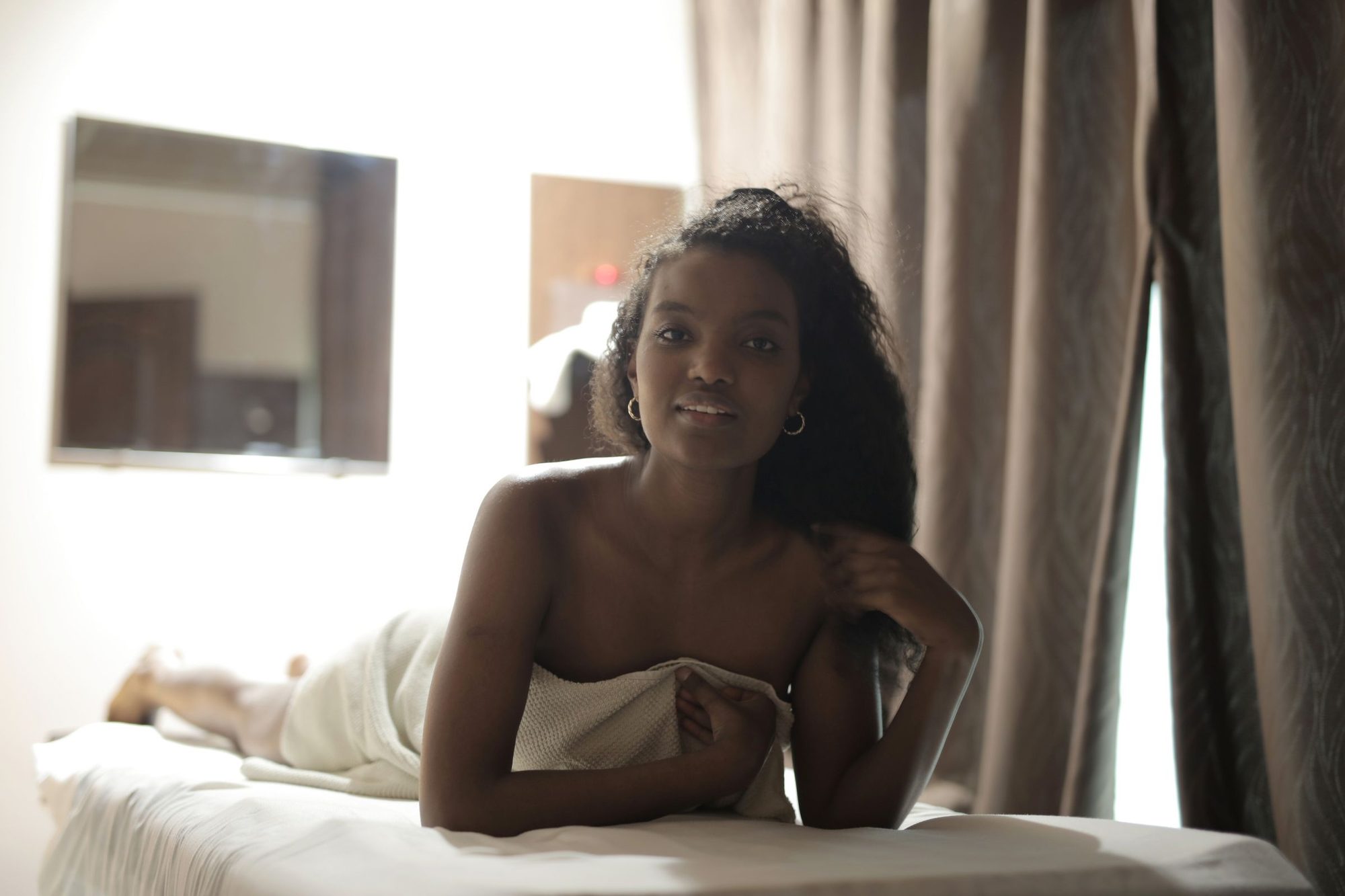 Guest relaxing on a treatment bed between candles