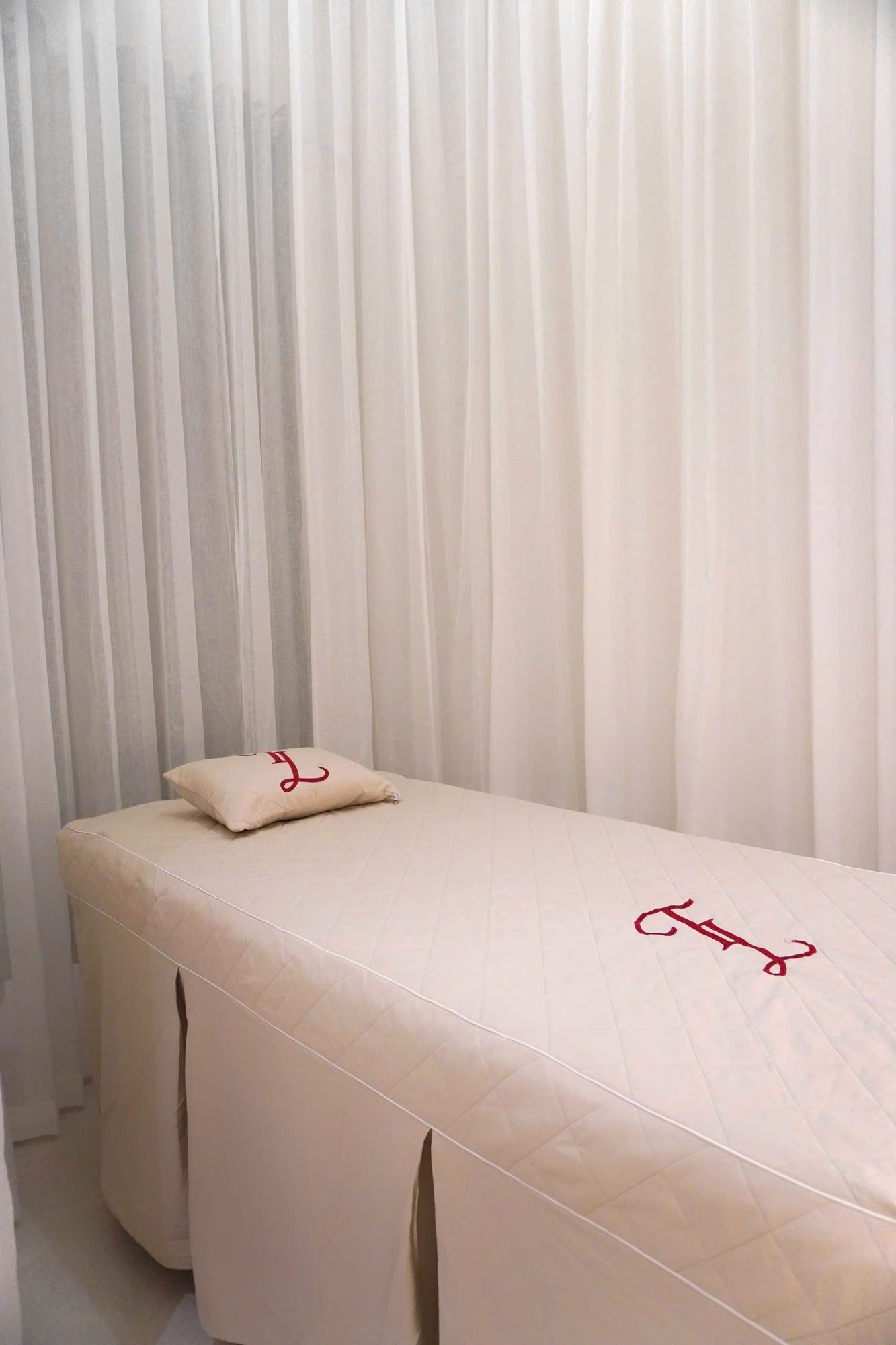 Minimal treatment room with a white massage bed and soft daylight
